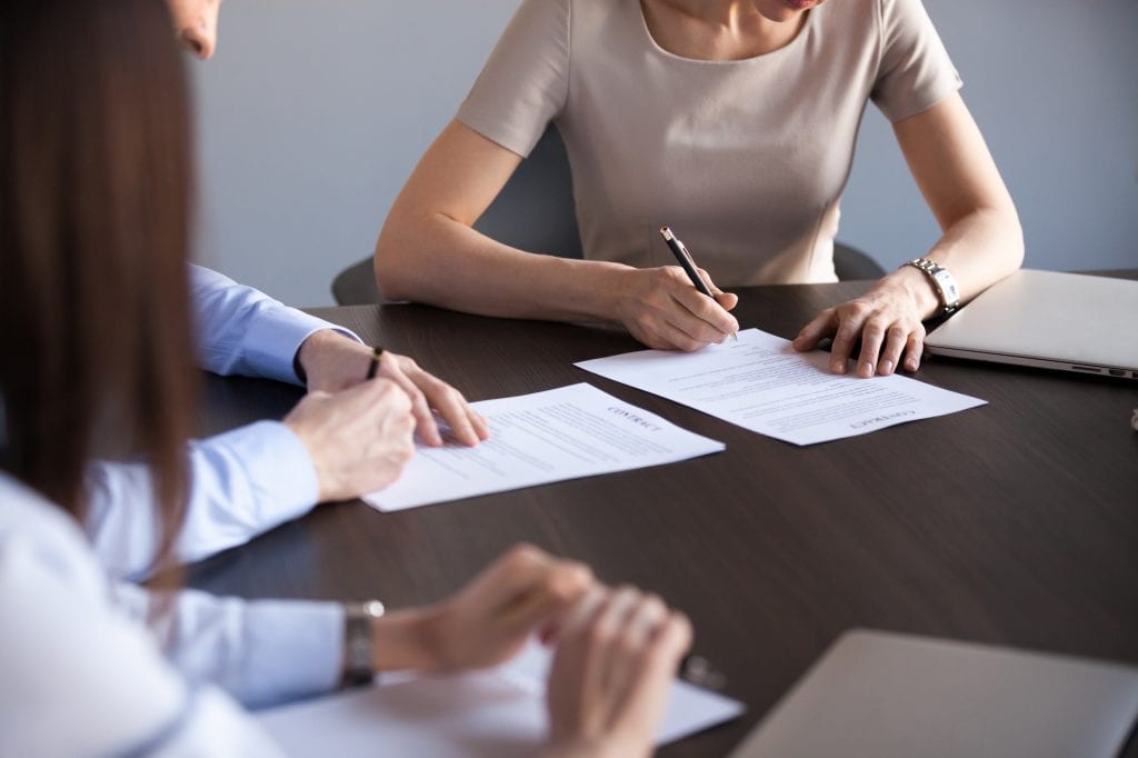 Couple reviews and signs documents during a divorce mediation session.