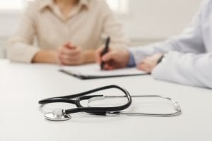 Family member reviewing a loved one's living will with a doctor.