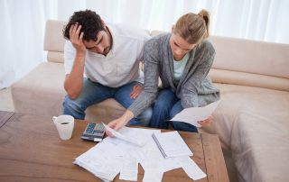 Couple paying bills and contemplating debt consolidation vs. personal bankruptcy.